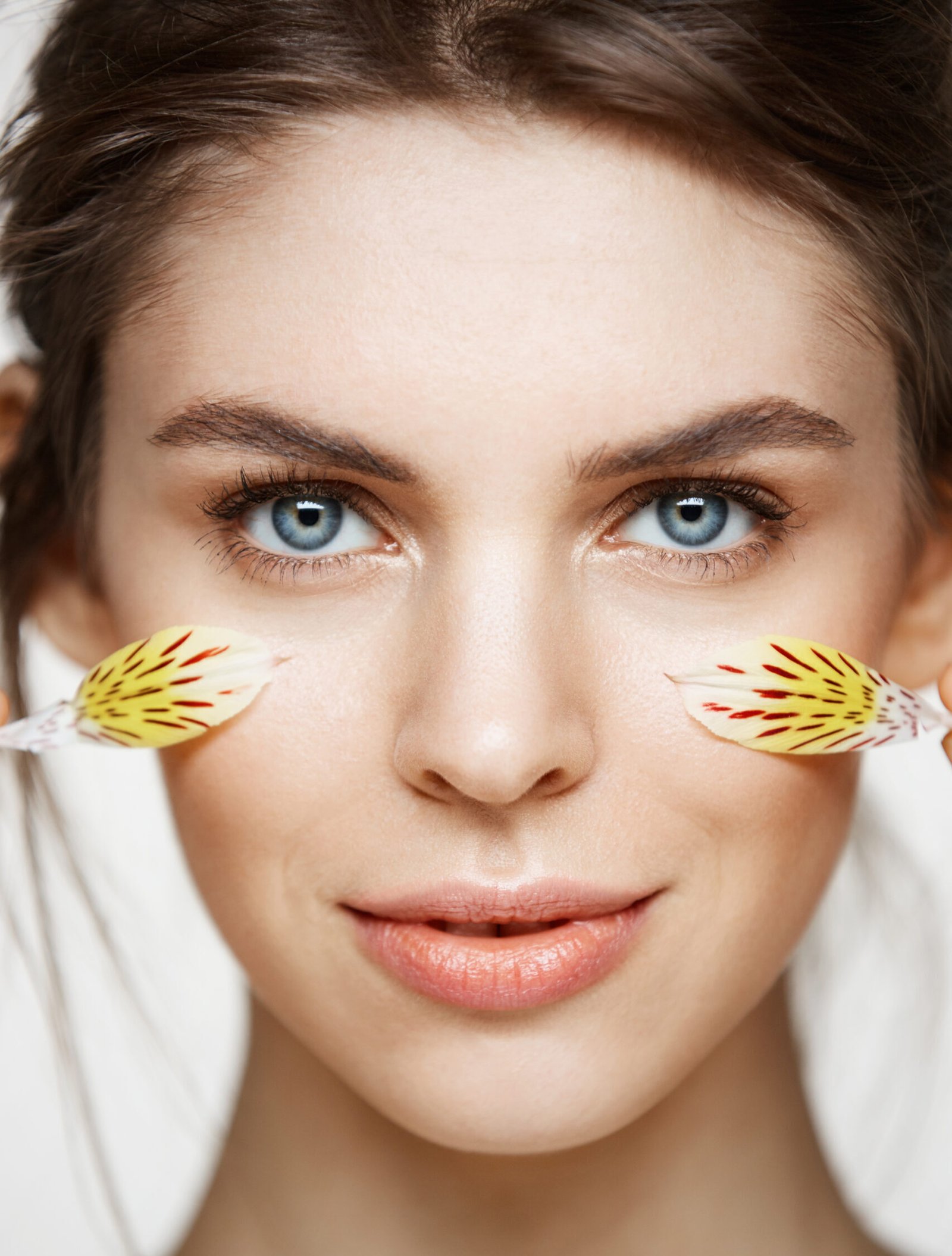 close up beautiful young girl with perfect clean skin alstroemeria petals looking camera white background facial treatment beauty spa scaled e1789140720831