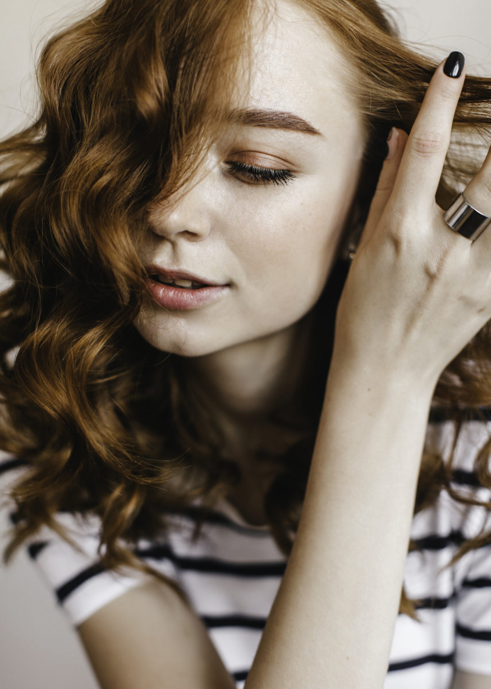 close up portrait sensual ginger lady with brown makeup indoor photo glad female model playing with her red wavy hair scaled e1789140773506