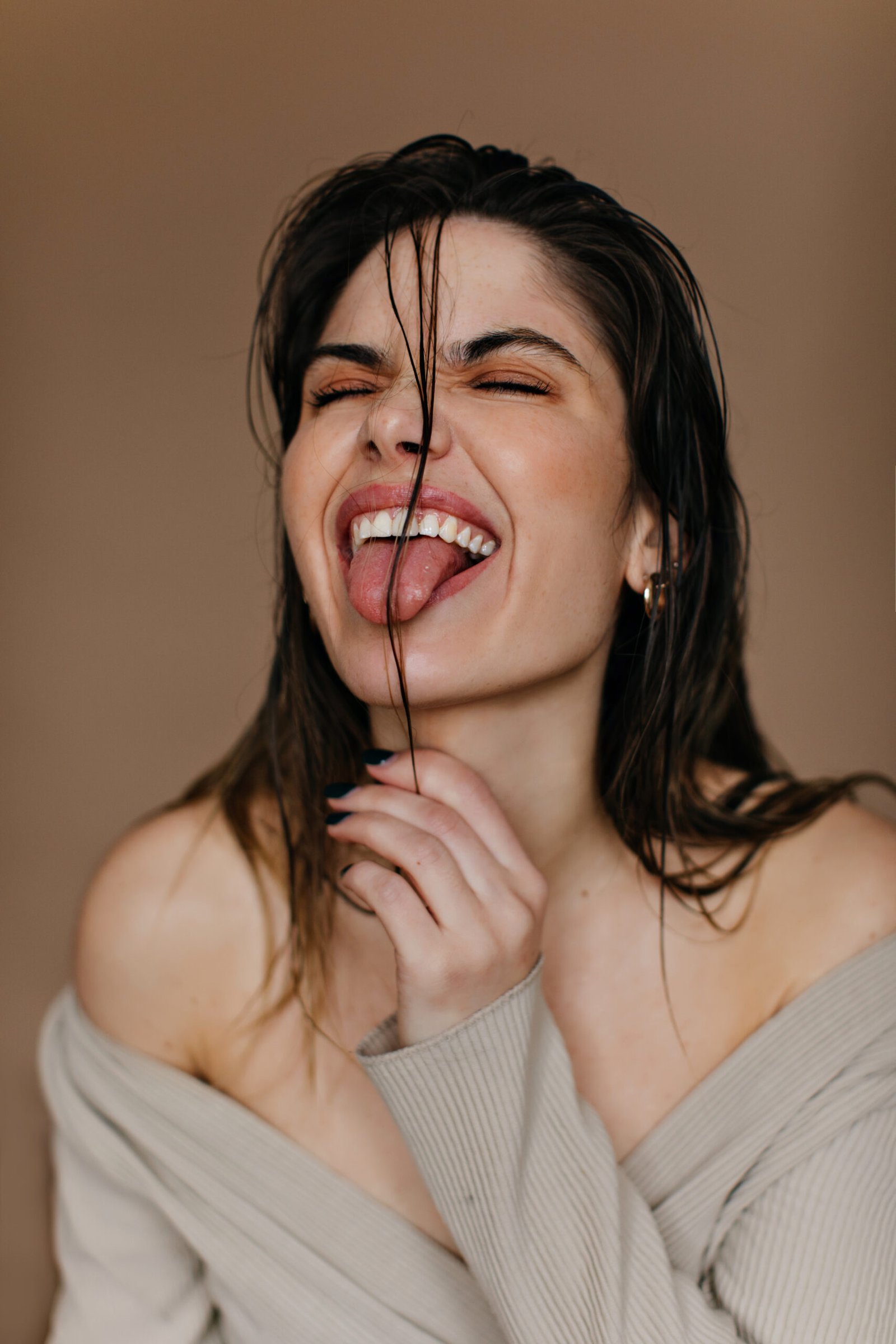 enthusiastic lady making funny faces european girl fooling around brown wall scaled