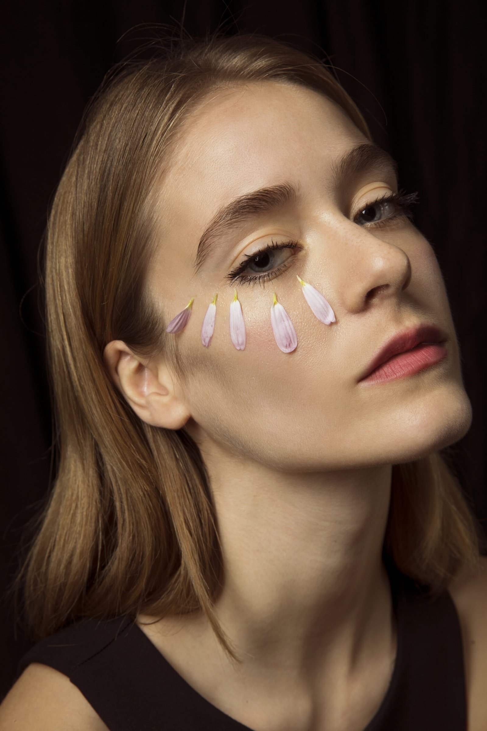 thoughtful woman with flower petals face scaled